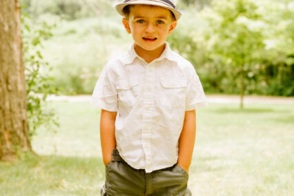 Alexander standing with hands in his pocket and a fedora