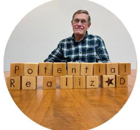 Peter Findlay infront of building blocks that say "Potential Realized"